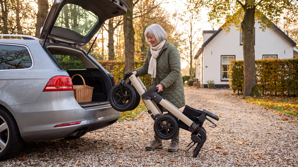 Folded Parvum Luxo Air in champagne; a woman lifts it into the trunk of her car on a gravel driveway.