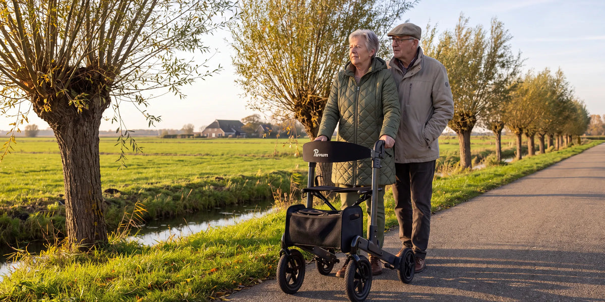 Parvum Luxo Air in anthracite on a polder road; a woman stands behind the rollator, her husband just behind her.