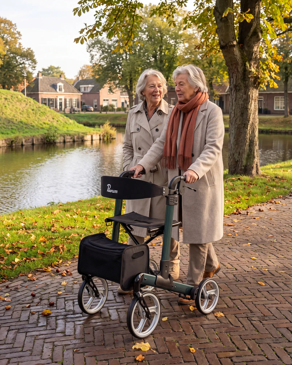 Parvum Luxo in petrol green along a town moat; two friends walk together, one of them with the rollator.