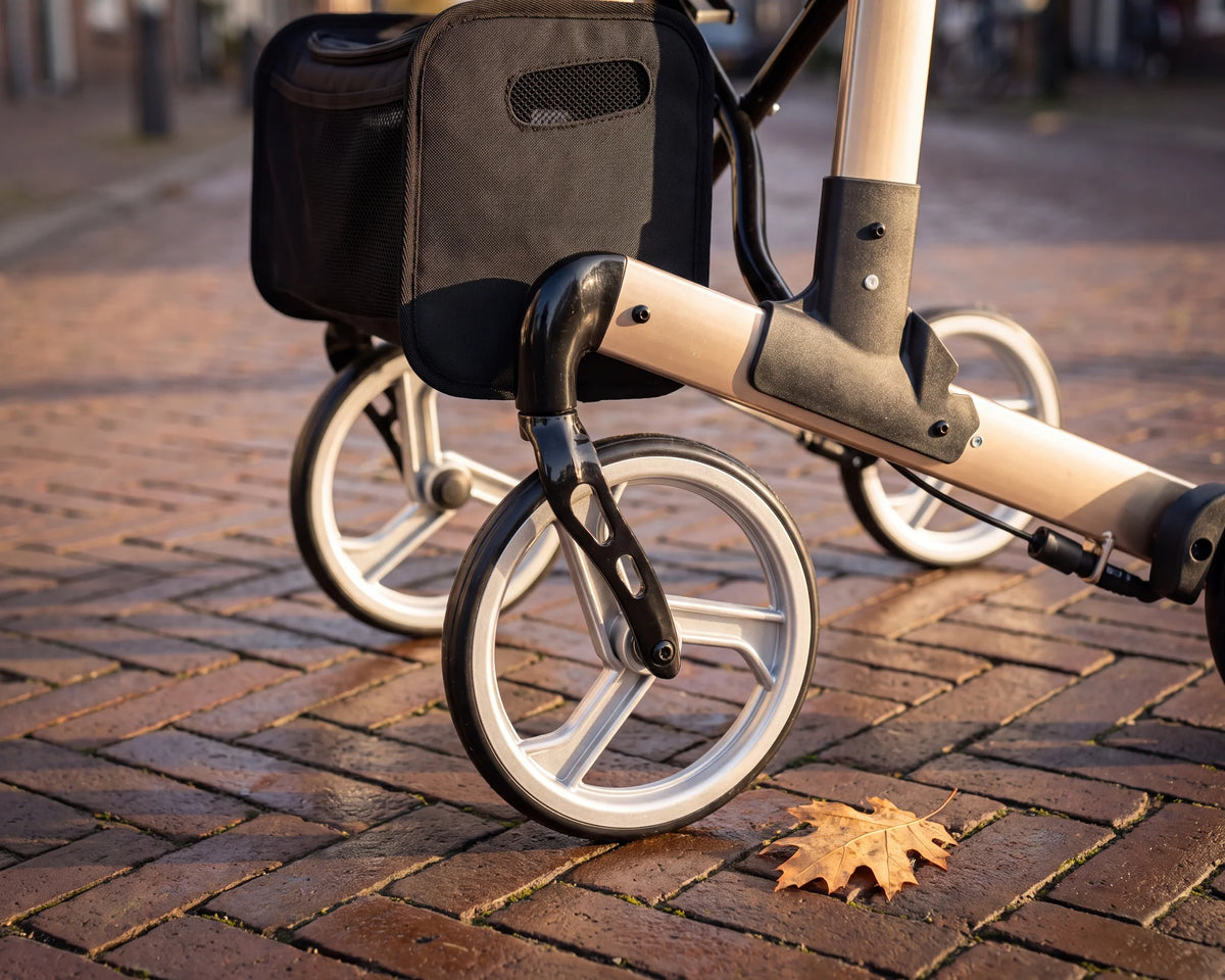 Close-up of the front wheel, the fork and the bag of the Parvum Luxo in champagne on cobbles.
